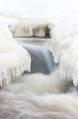 Fototapeta na wymiar Flowing river and icicles in winter