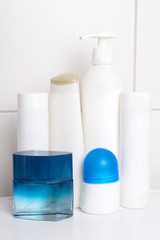 set of white cosmetic bottles over tiled wall