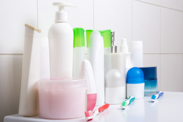 collection of white cosmetic bottles over tiled wall