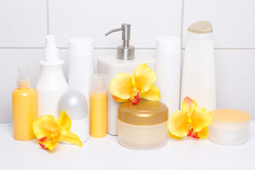 Fototapeta na wymiar set of white cosmetic bottles and hygiene supplies with orange o