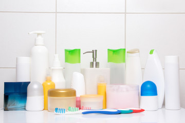 set of colorful cosmetic bottles over white tiled wall