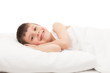 cheerful boy in white bed