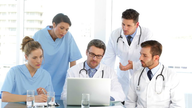 Doctor speaking with his staff during a meeting