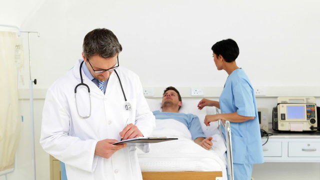 Doctors and nurse watching over sick patient