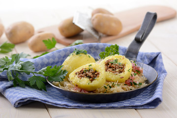Mit Hackfleisch gefüllte Kartoffelknödel auf Speckkraut