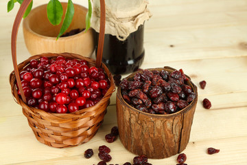 Fresh and dry cranberry in baskets on wooden table