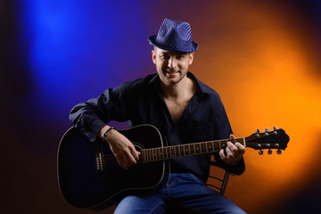 Obraz premium Young musician playing acoustic guitar and singing,