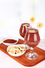 Cocktails with banana and chocolate on table on light