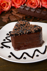Sweet cake with chocolate on plate on table close-up