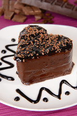 Sweet cake with chocolate on plate on table close-up