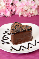 Sweet cake with chocolate on plate on table close-up