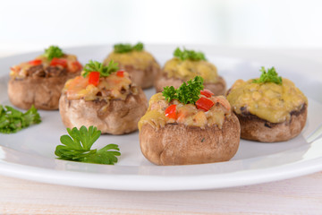 Stuffed mushrooms on plate on table on light background