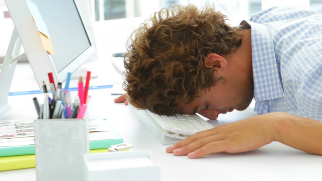 Exhausted businessman sleeping with his head on the keyboard