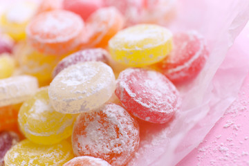 Sweet  multicolor candies on paper, on color background