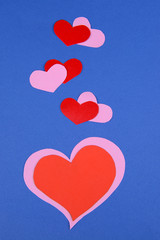 Fototapeta na wymiar Paper hearts on blue background