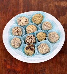 Set of chocolate candies, on plate, on wooden background