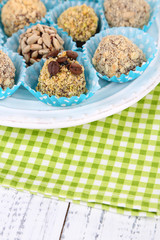 Set of chocolate candies, on plate, on wooden background