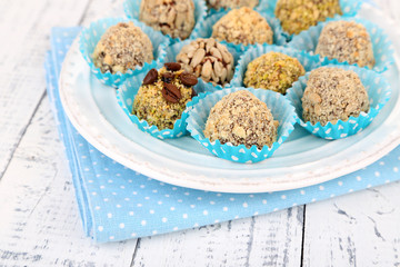 Set of chocolate candies, on plate, on wooden background