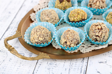 Set of chocolate candies, on tray, on color wooden background