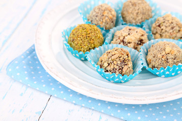 Set of chocolate candies, on plate, on wooden background