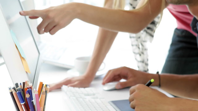 Attractive blonde creative designer helping her colleague