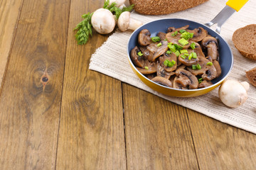 Delicious fried mushrooms in pan on table close-up