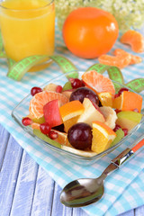Sweet fresh fruits in bowl on table close-up