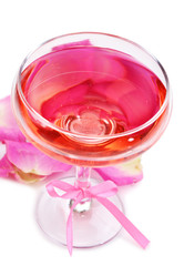Composition with pink sparkle wine in glass and  rose petals