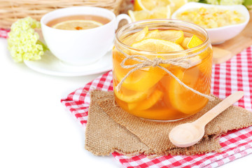 Tasty lemon jam with cup of tea on table close-up