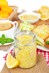 Tasty lemon jam with cup of tea on table close-up