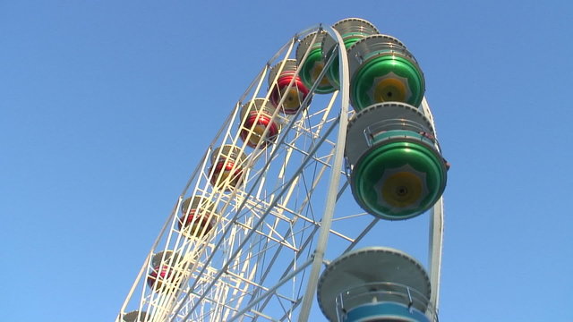 Riesenrad dreht sich gegen blauen Abendhimmel