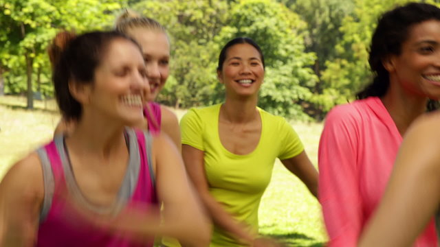 Smiling zumba class dancing in the park
