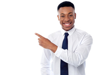 Smiling businessman pointing away