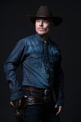 Modern fashion cowboy. Wearing brown hat and blue jeans shirt. P