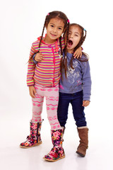 petites filles avec des couettes chahute avec sa soeur - obrazy, fototapety, plakaty