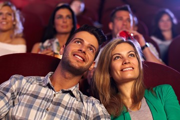 Happy couple watching movie in cinema - obrazy, fototapety, plakaty