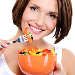 Young woman eats vegetable