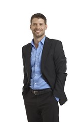 Happy businessman standing with hands in pockets
