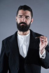 Retro hipster 1900 fashion man with black hair and beard. Smokin