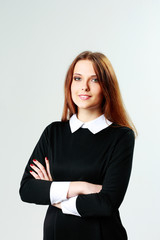 Obraz premium Portrait of a young smiling woman standing with arms folded