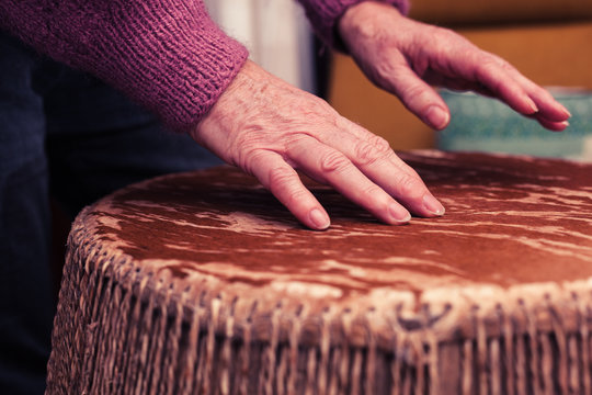 Old woman playing bongo drums