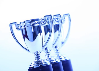 Toy Silver Trophy Cups in a row in cool blue light