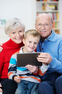 großeltern mit enkel und tablet-pc