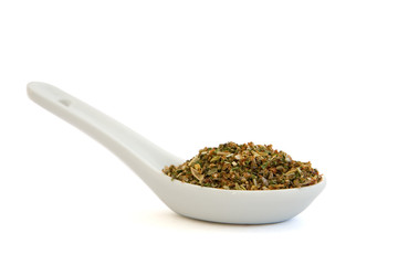 White spoon filled with herbs and spices mix