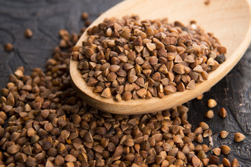 Buckwheat seeds on wooden spoon in closeup