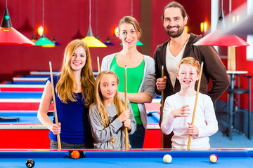 Familie spielt Poolbillard oder Billard