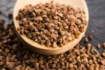 Buckwheat seeds on wooden spoon in closeup