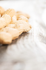 Peanuts in shell on wooden table high key