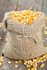 corn in burlap bag on wooden surface