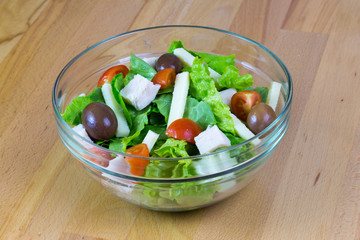 Bowl of fresh vegetable salad served on a wooden table